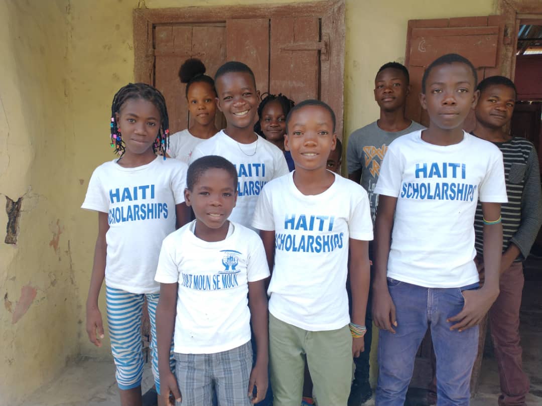 A group of smiling students in Haiti Scholarships shirts
